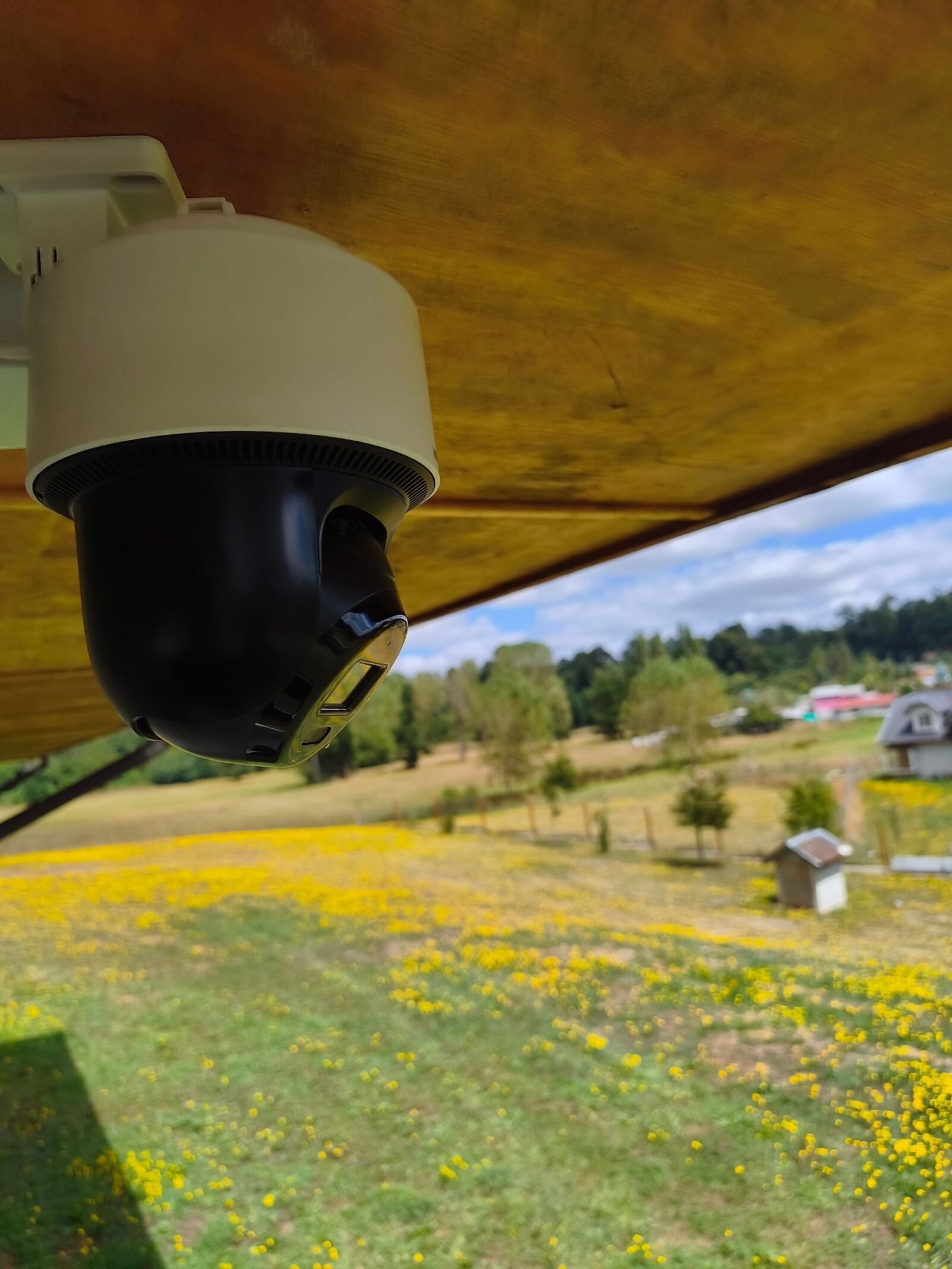 Cámara PTZ Hikvision en exterior de casa rural, vista lateral con soporte de pared, Oromo